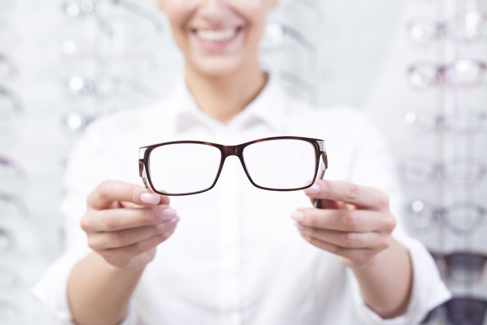 woman holding a new pair of glasses